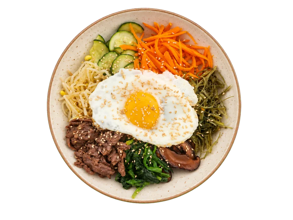 Bibimbap topped with a fried egg, beef and colourful vegetables.